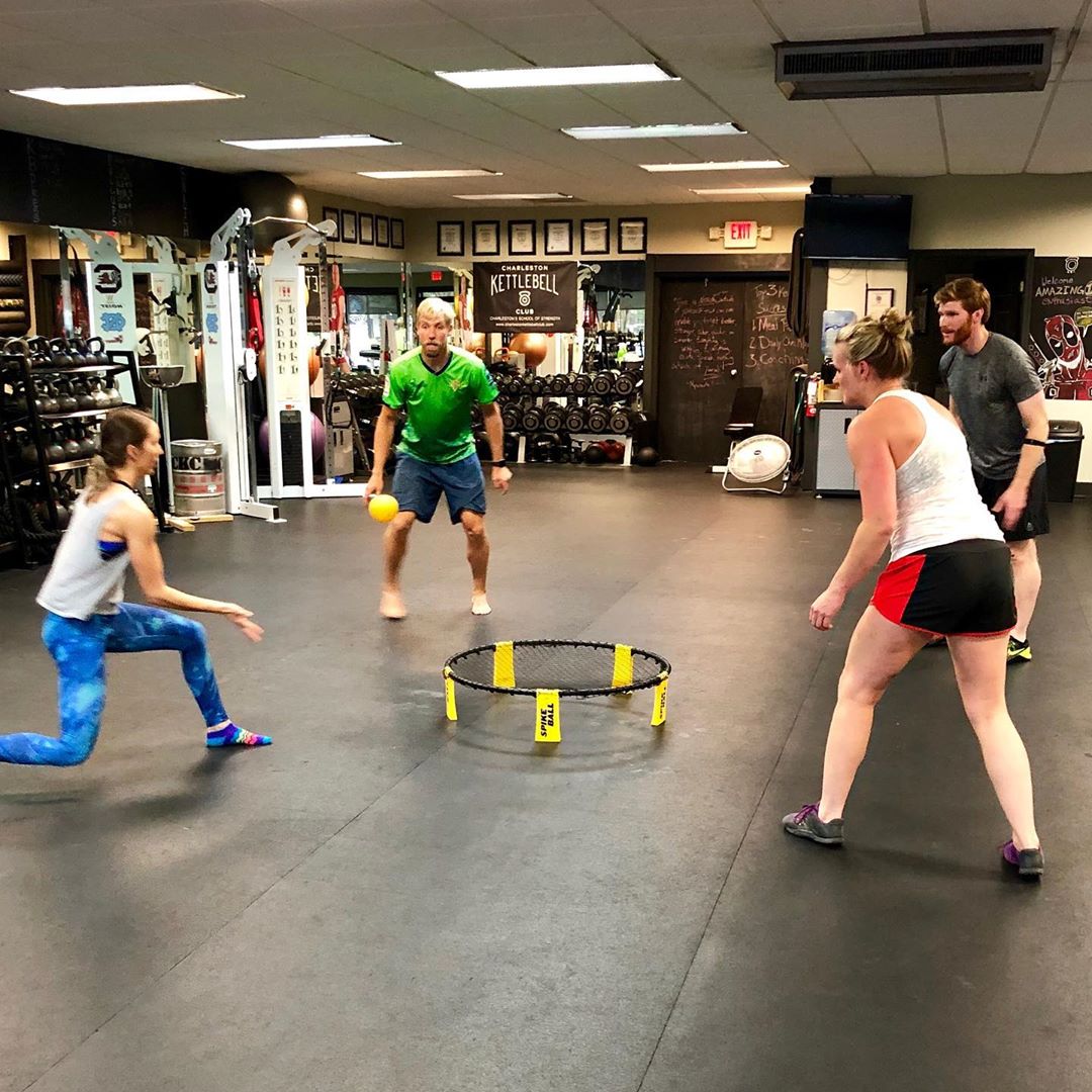 Members play a round of Spikeball on the gym floor.