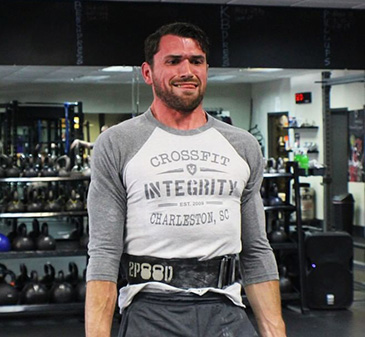 Grimacing at the top of the pull, belt cinched tight.